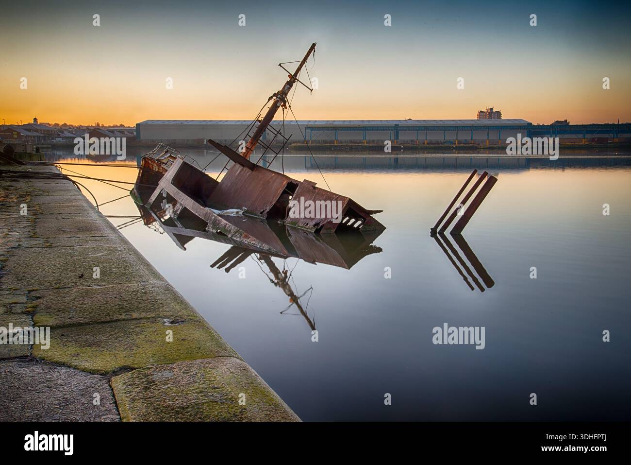 Der verrostete Rumpf des Schiffswracks Sarsia tauchte im East Float Dock in Birkenhead teilweise in Wasser Stockfoto