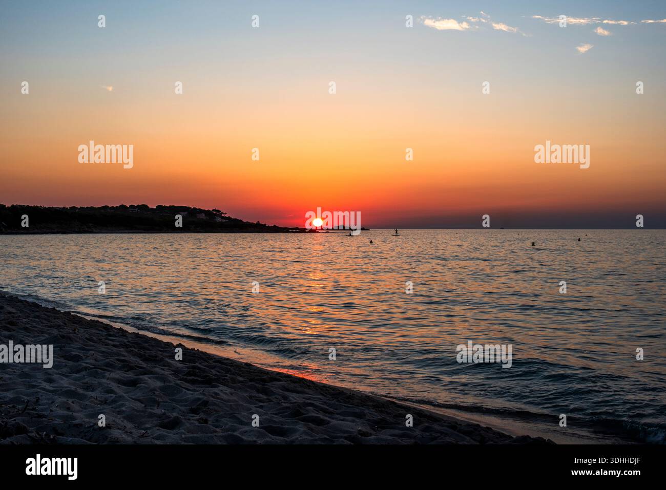 Golden Hour Sonnenlicht reflektiert auf sanften Wellen bei Sonnenuntergang entlang der korsischen Küste, Frankreich. Eine warme und zeitlose Meereslandschaft, die Ruhe, Balance und C vermittelt Stockfoto