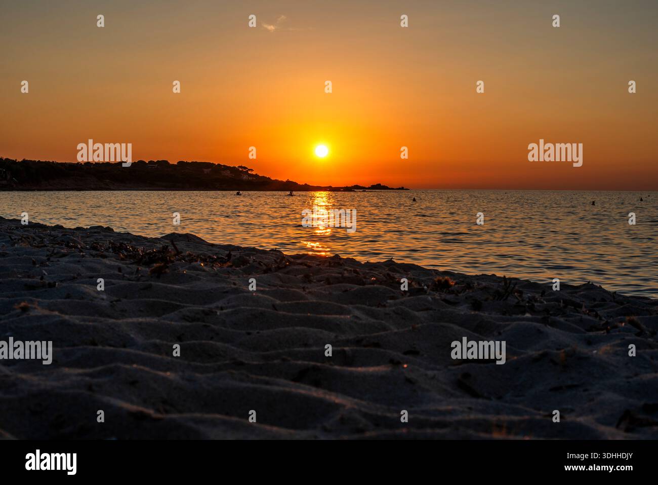 Goldene Sonne, die über dem mediterranen Horizont schwebt, mit glitzernden Reflexen auf dem Meer, Korsika, Frankreich. Eine zeitlose Sonnenuntergang Komposition, die W Stockfoto
