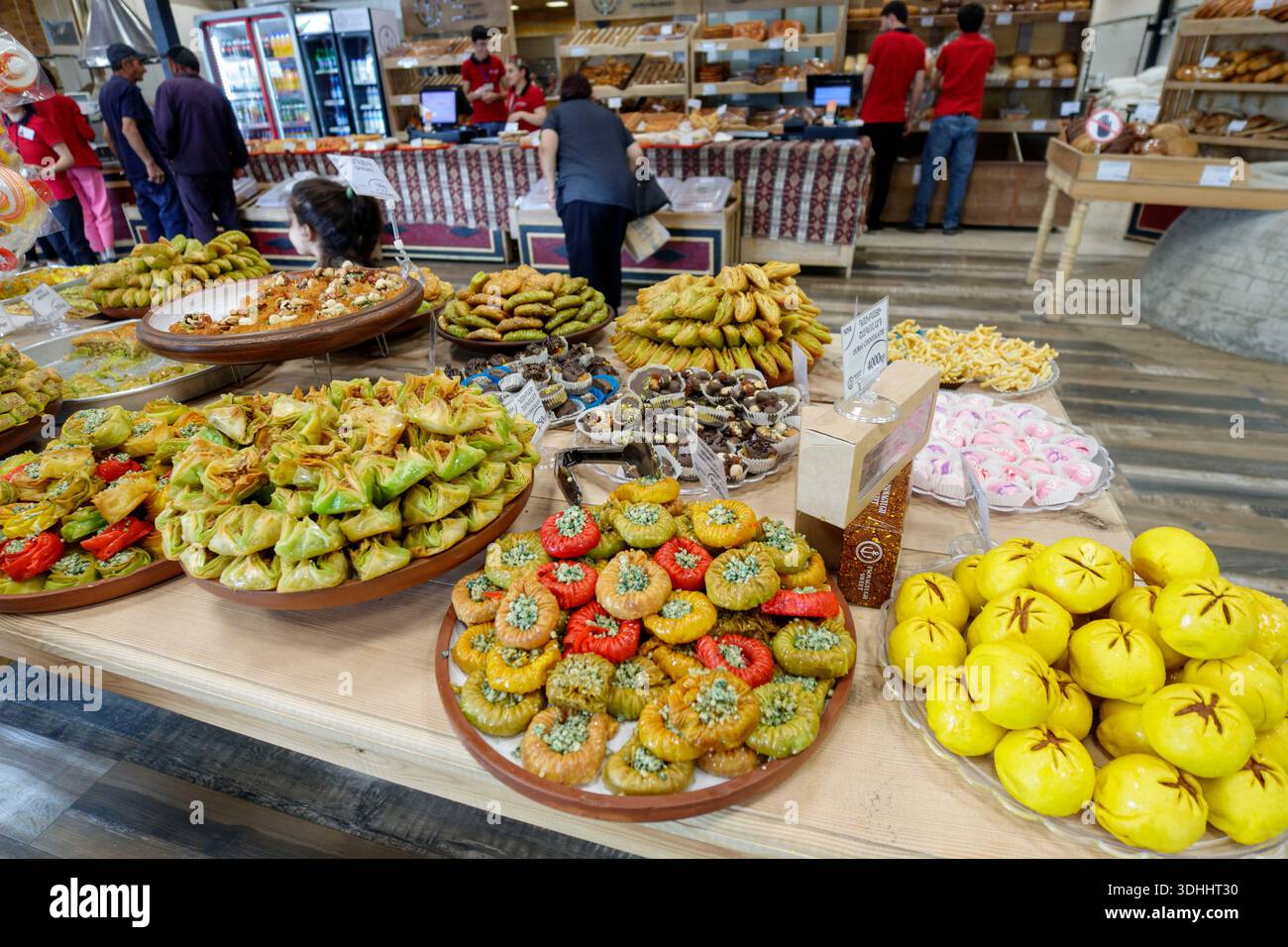 Große Auswahl an traditionellen armenischen Süßigkeiten, die an einer Theke in einer geschäftigen Bäckerei in Armenien, Osteuropa, ausgestellt werden Stockfoto