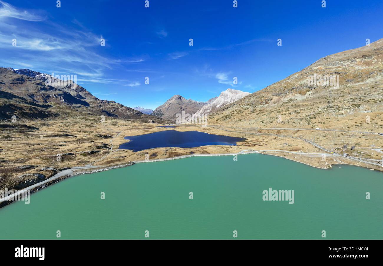 Aus der Vogelperspektive auf den ruhigen Lago Bianco und das kontrastierende türkisfarbene Wasser des Lago di Monte Moro eingebettet in das zerklüftete, bergige Gelände Berni Stockfoto