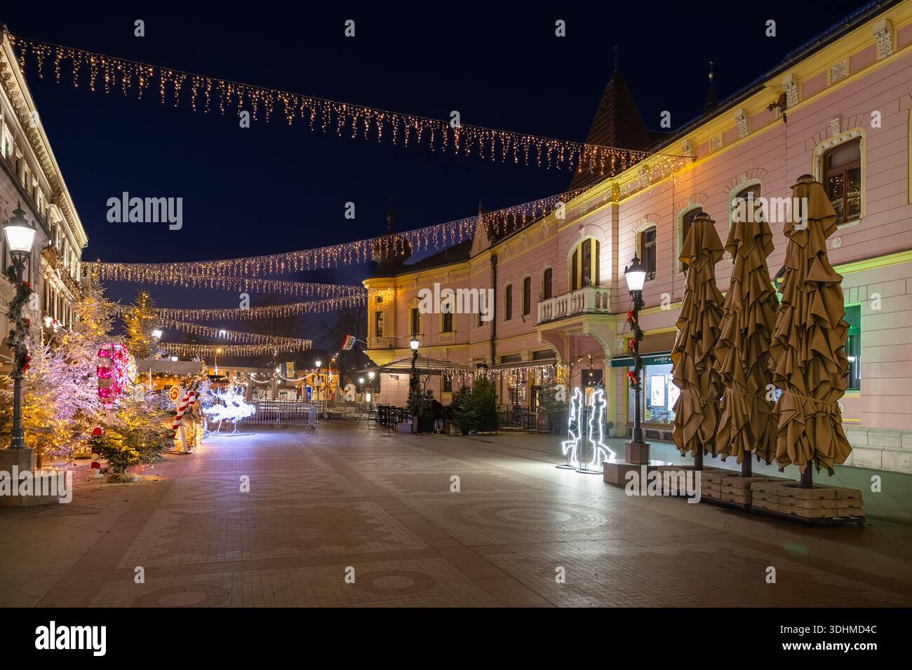 Das Bild zeigt die Fußgängerzone in Vinkovci während der Adventsveranstaltung in Vinkovci. Eine festliche europäische Straßenszene zur blauen Stunde mit einem Rosa Stockfoto