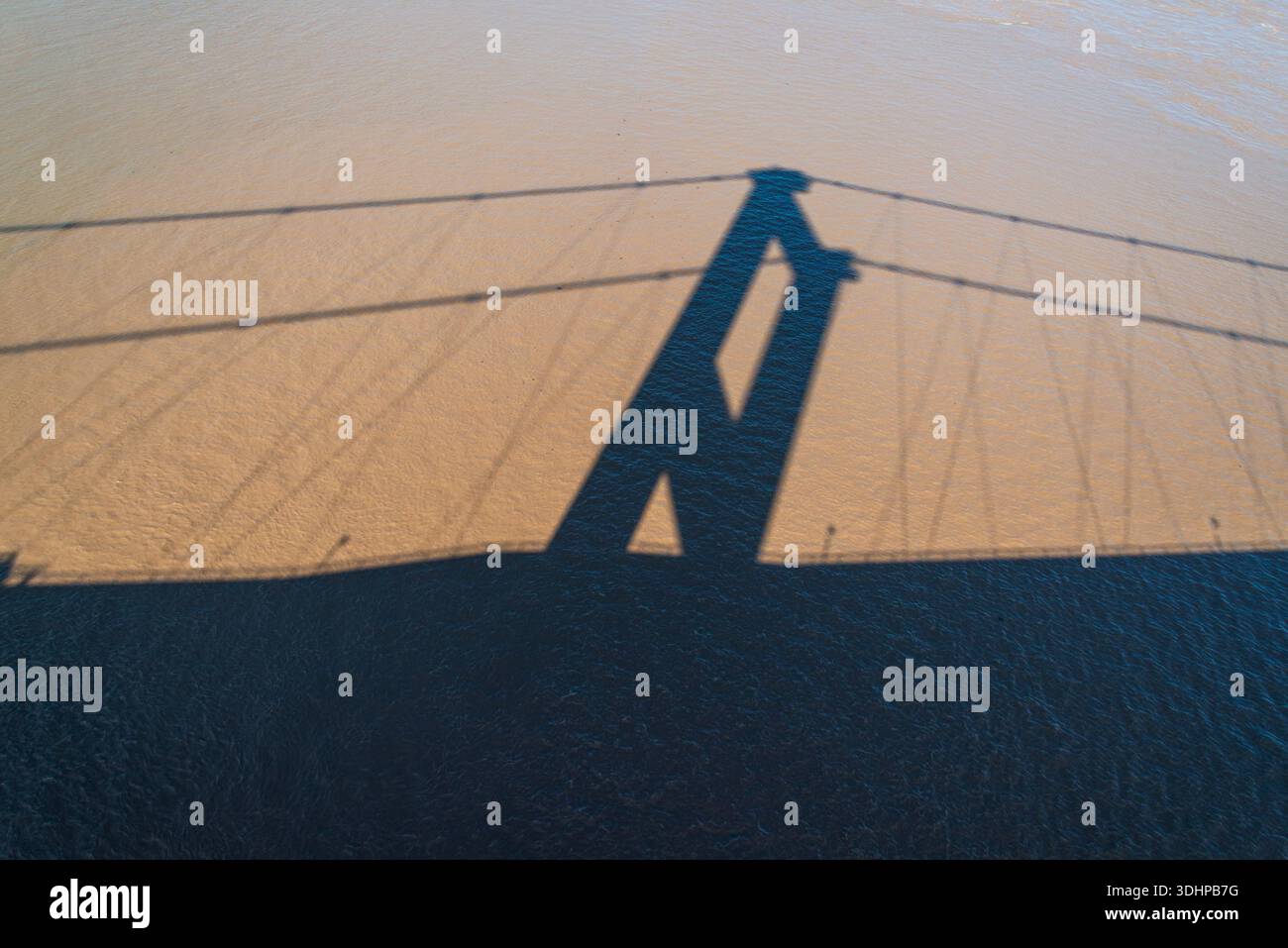 Abstrakter Schatten der Prince of Wales Bridge über die Oberfläche der Severn Mündung Stockfoto