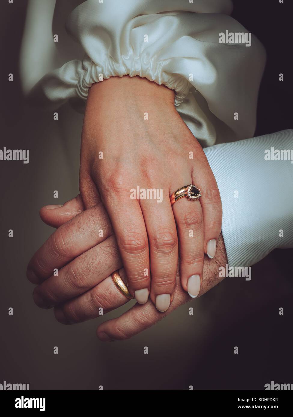 Ein Paar Jungvermählte, die an ihrem Hochzeitstag die Hände halten Stockfoto