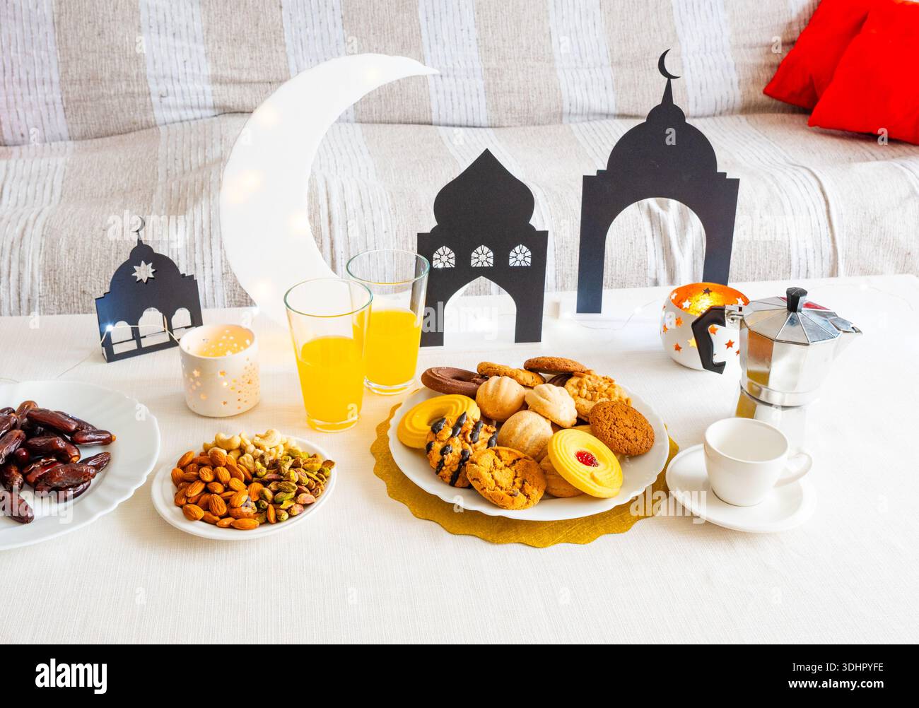 EID Mubarak-Tisch mit Ramadan-Süßigkeiten, Datteln, Nüssen und festlicher Einrichtung Stockfoto
