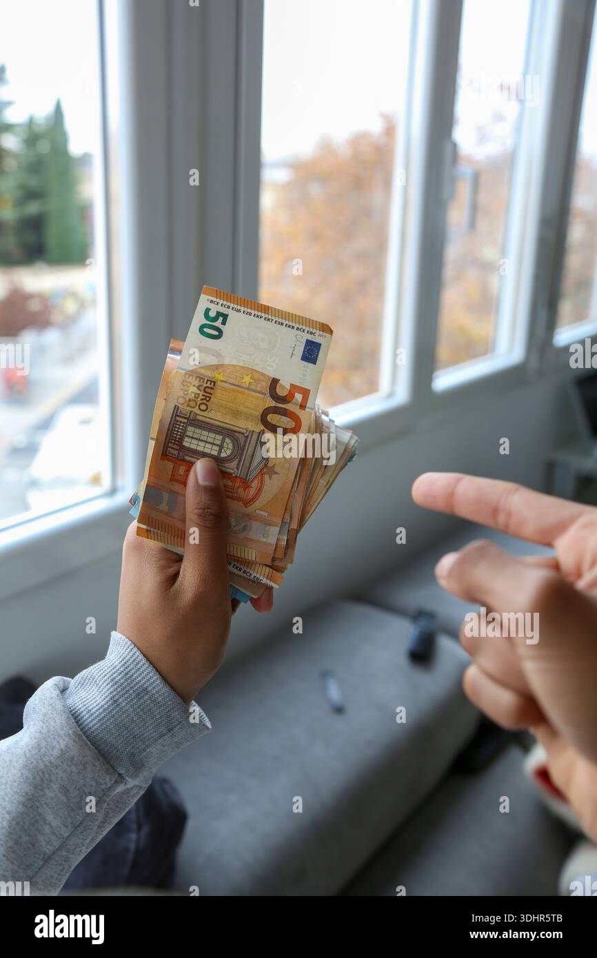 Ein Stück 50-Euro-Scheine, die von einer afroamerikanischen Frau gehalten werden Stockfoto