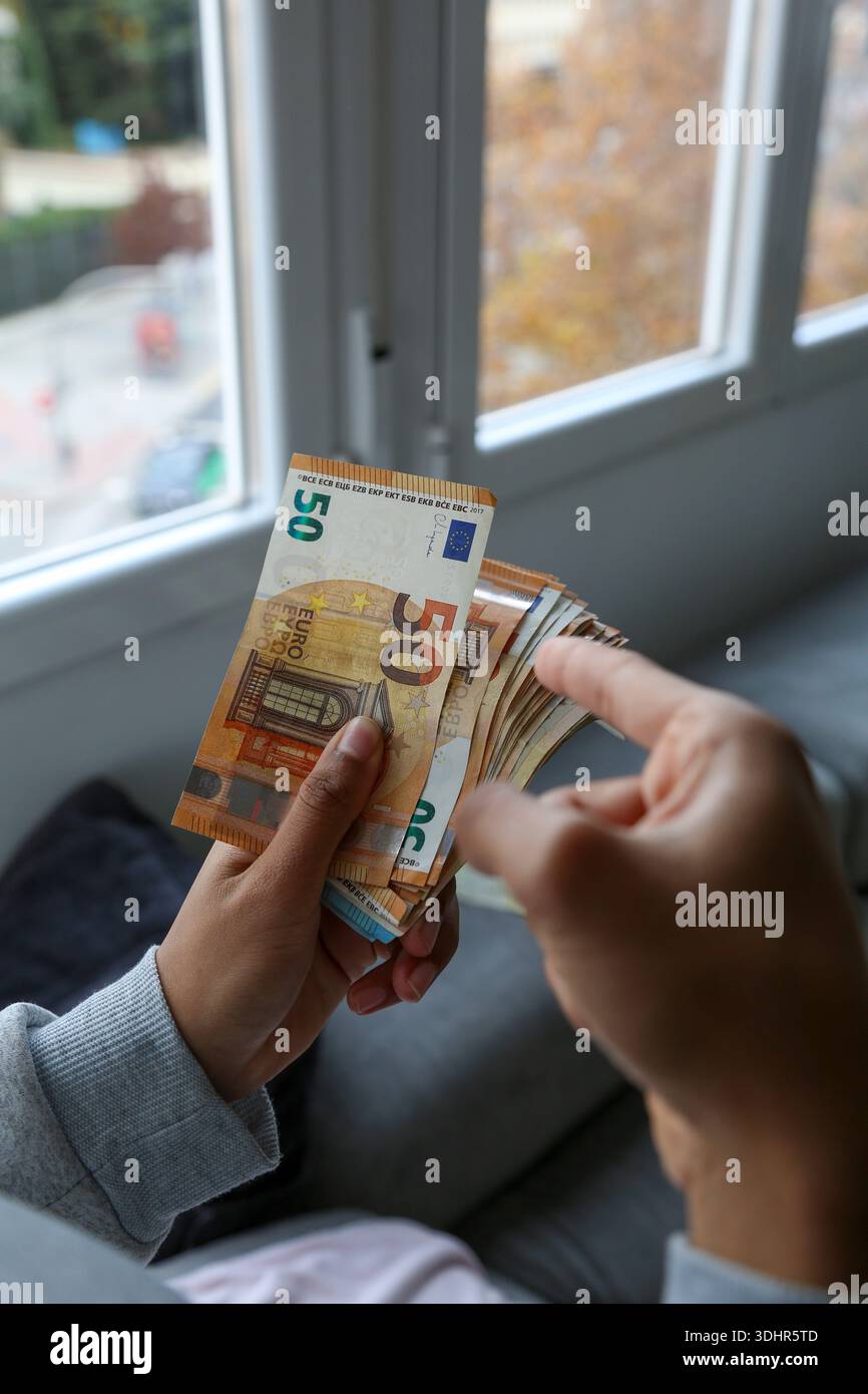 Ein Stück 50-Euro-Scheine, die von einer afroamerikanischen Frau gehalten werden Stockfoto