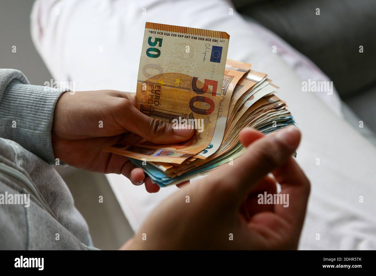 Ein Stück 50-Euro-Scheine, die von einer afroamerikanischen Frau gehalten werden Stockfoto