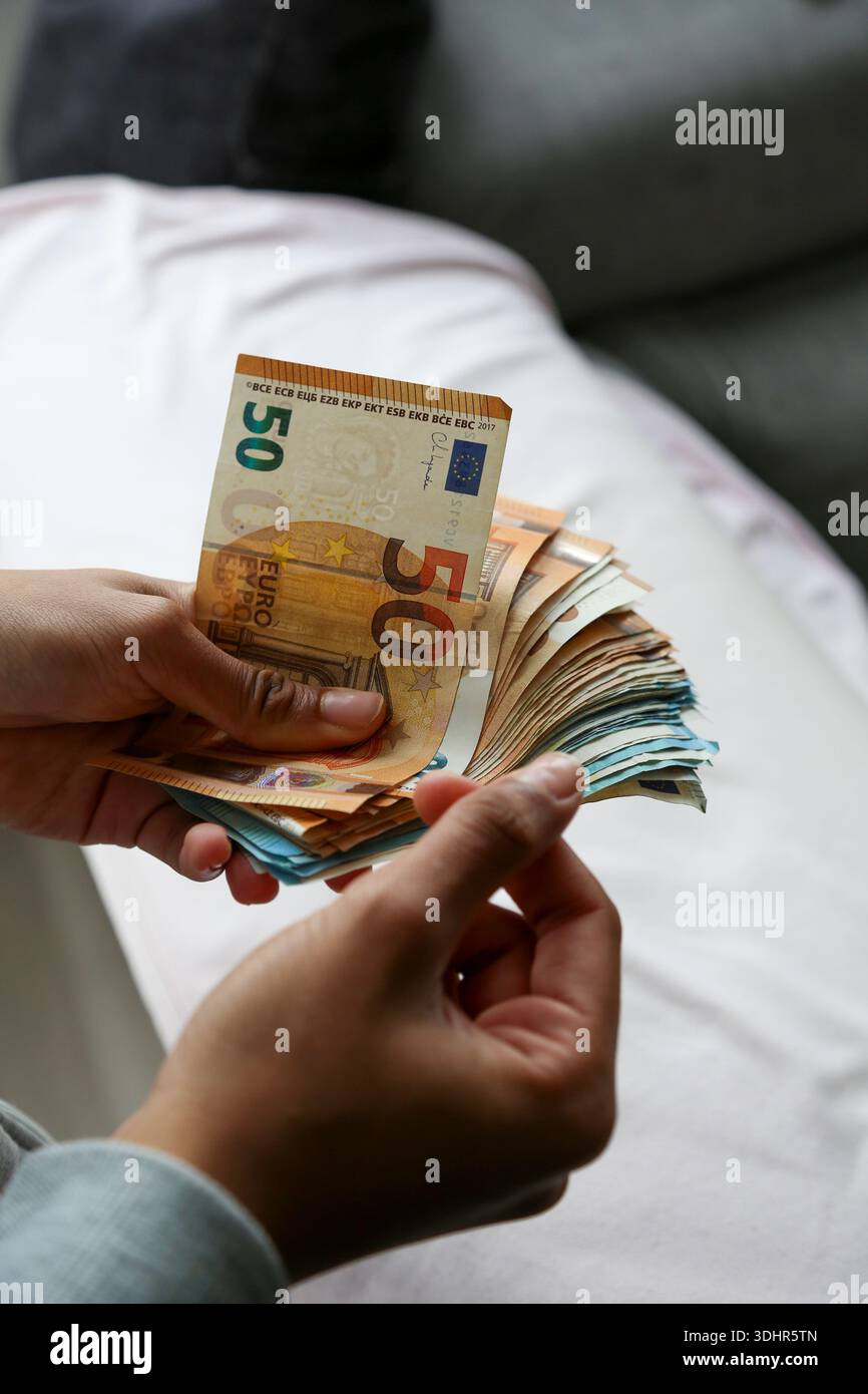 Ein Stück 50-Euro-Scheine, die von einer afroamerikanischen Frau gehalten werden Stockfoto