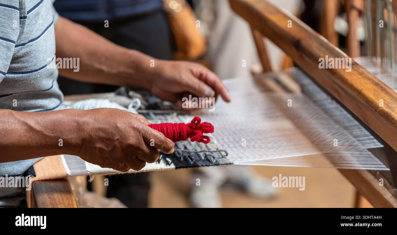 Indigener Mann, der Textilien und Stoffe webt, Otavalo, Ecuador. Stockfoto