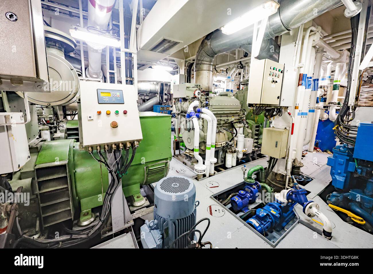 Schiffsmaschinenraum mit Diesel-Generator, Pumpen, Schalttafeln und isolierten Rohrleitungen im Maschinenraum für gewerbliche Schiffe. Stockfoto