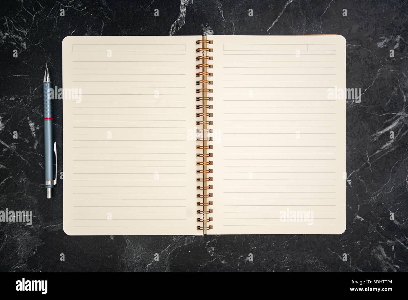 Spiralnotizbuch auf dunklem Marmorschreibtischhintergrund öffnen. Hochwertige Fotos Stockfoto