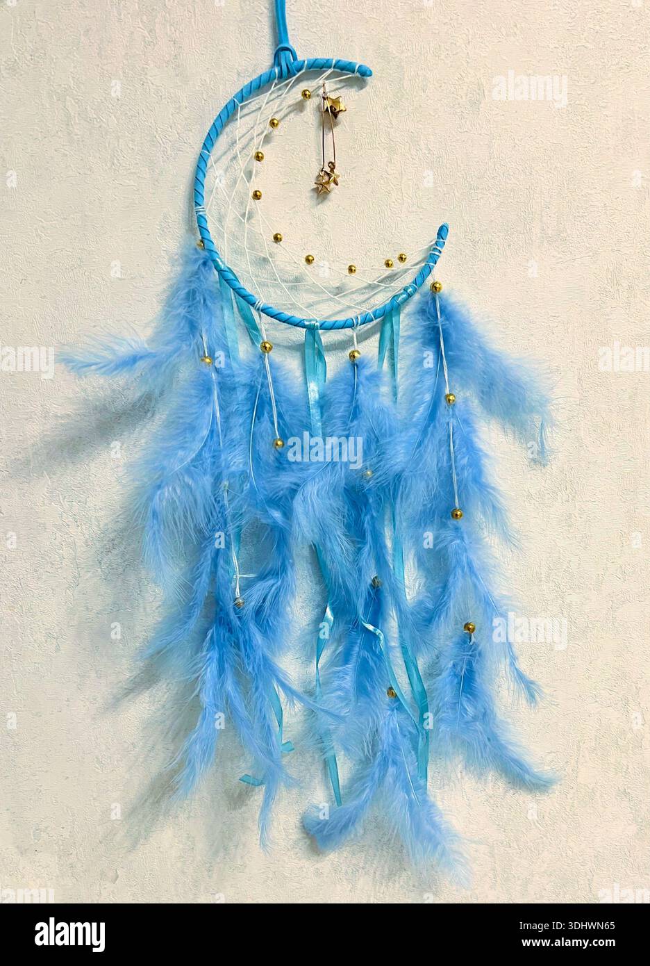 Nahaufnahme eines Traumfangers mit blauen Federn, handgefertigte DIY-Dekoration im Boho-Stil Stockfoto