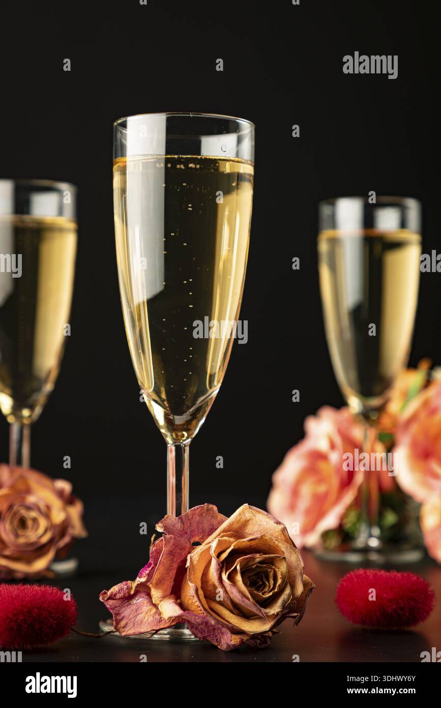 Drei Gläser mit Rosen und Herzen, dunkler Hintergrund Stockfoto