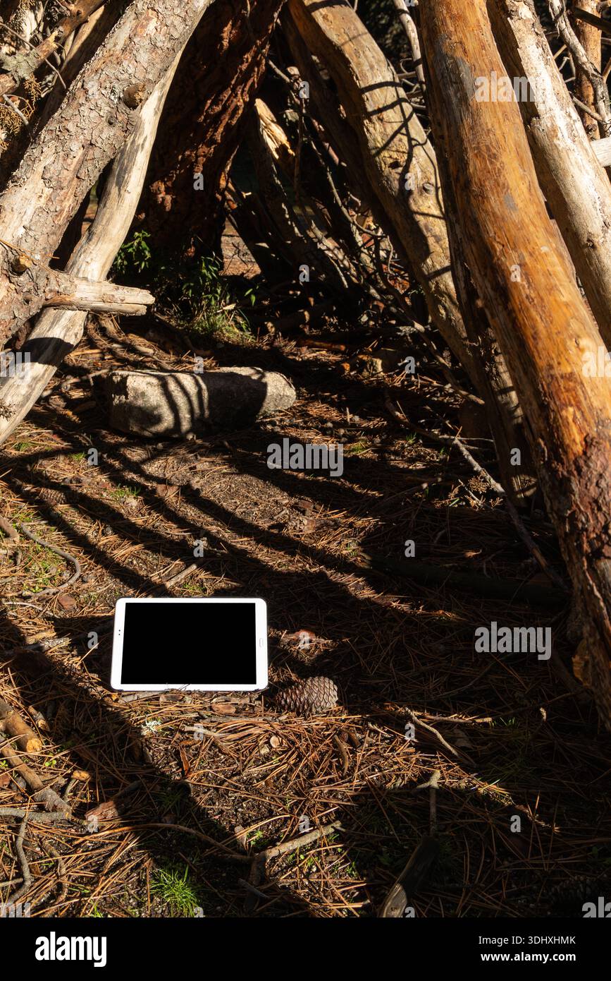 Tablet mit leerem Bildschirm im ländlichen Raum, das moderne Technologie mit Natur kombiniert und für Designer, Vorlagen oder Branding geeignet ist. Stockfoto