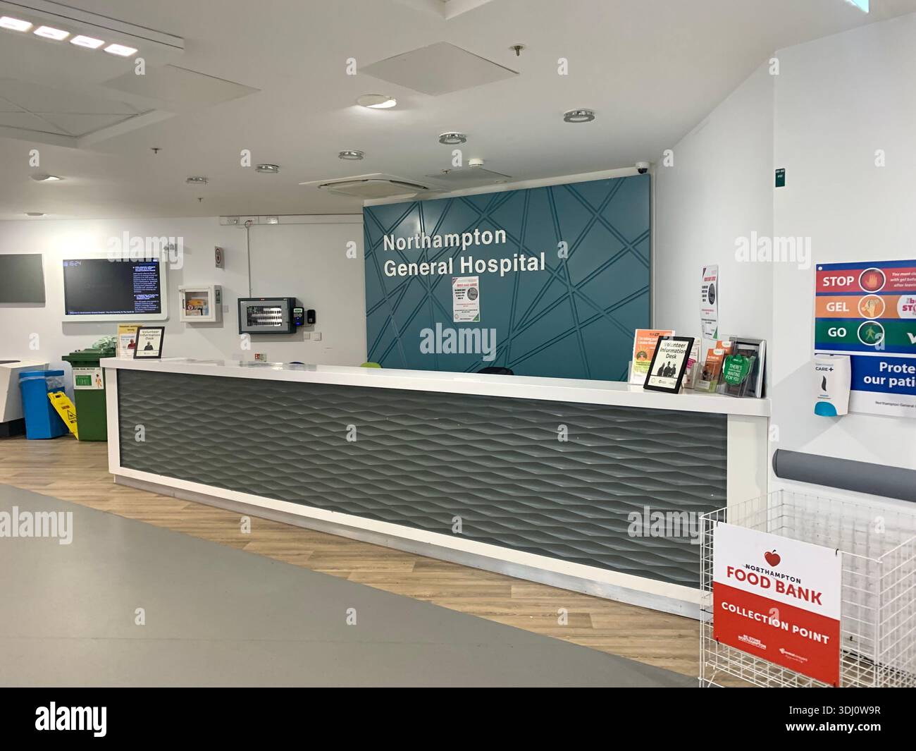 Krankenhauskorridor im Northampton General Hospital England mit Schildern für Patientenbettträger und COVID-19-sozialer Distanzierung - Smartphone-aufgenommenes Stockfoto