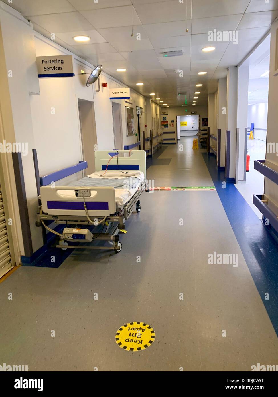 Krankenhauskorridor im Northampton General Hospital England mit Schildern für Patientenbettträger und COVID-19-sozialer Distanzierung - Smartphone-aufgenommenes Stockfoto