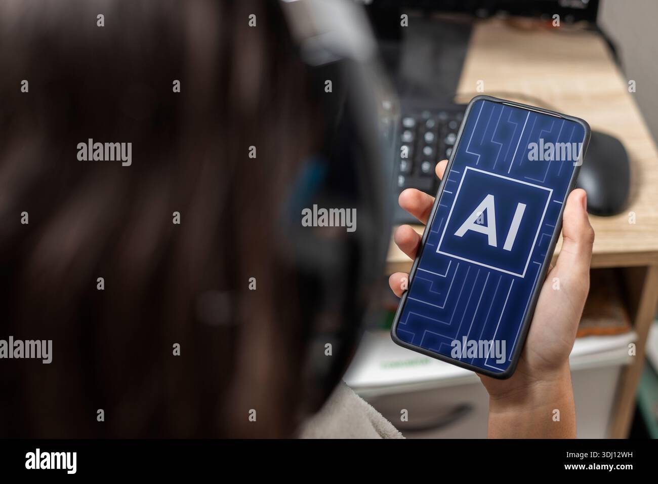 Eine nicht erkennbare Teenagerin, die Kopfhörer trägt und ein Handy mit der Hand hält. AI-Text wird auf dem Bildschirm angezeigt. Stockfoto