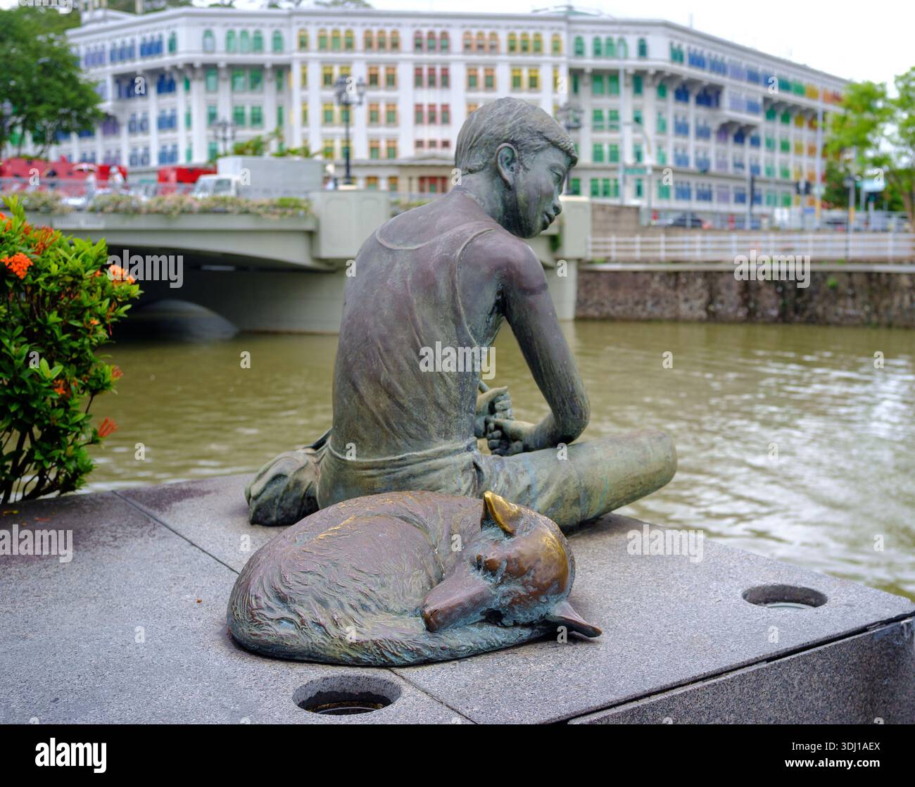 Eine Bronzeskulptur entlang des Singapore River Walk by der Skulptur Chern Lian Shan zeigt einen Jungen beim Angeln mit seinem Hund, der neben ihm schläft, als Anblick auf die Vergangenheit. Stockfoto