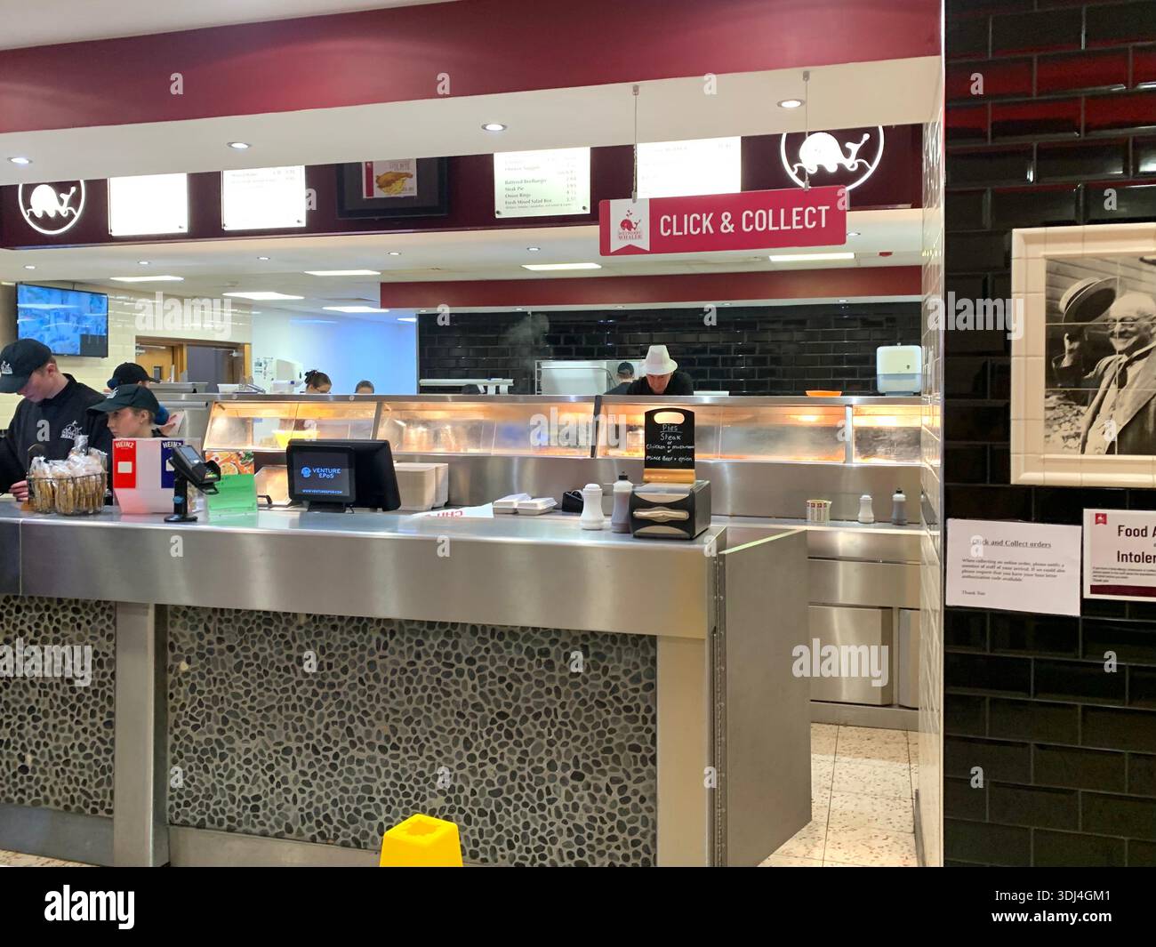 Fish and Chips Shop harry Ramsden Guiseley Yorkshire im Inneren West Yorkshires zeigt den Service-Schalter beleuchtete Menüs und Personal, das Bestellungen vorbereitet - Smartphone-aufgenommenes Stockfoto