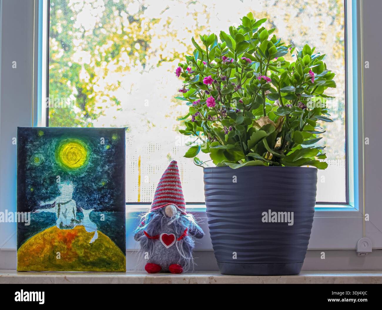 Gemütliches Interieur am Fenster. Ein Gemälde des Kleinen Prinzen, ein textiler Zwerg mit Herz und grüne Kalanchoe schaffen eine warme Atmosphäre Stockfoto