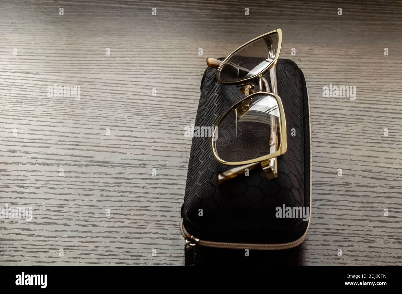 Eine Brille und Eine Schutzhülle befinden sich auf Einem Holztisch Stockfoto
