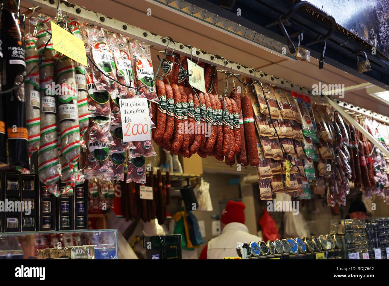 Traditionelle ungarische Wurst und Salami hängen an einem lokalen Metzgerstand mit Preisen in der zentralen Markthalle in Budapest, Ungarn Stockfoto