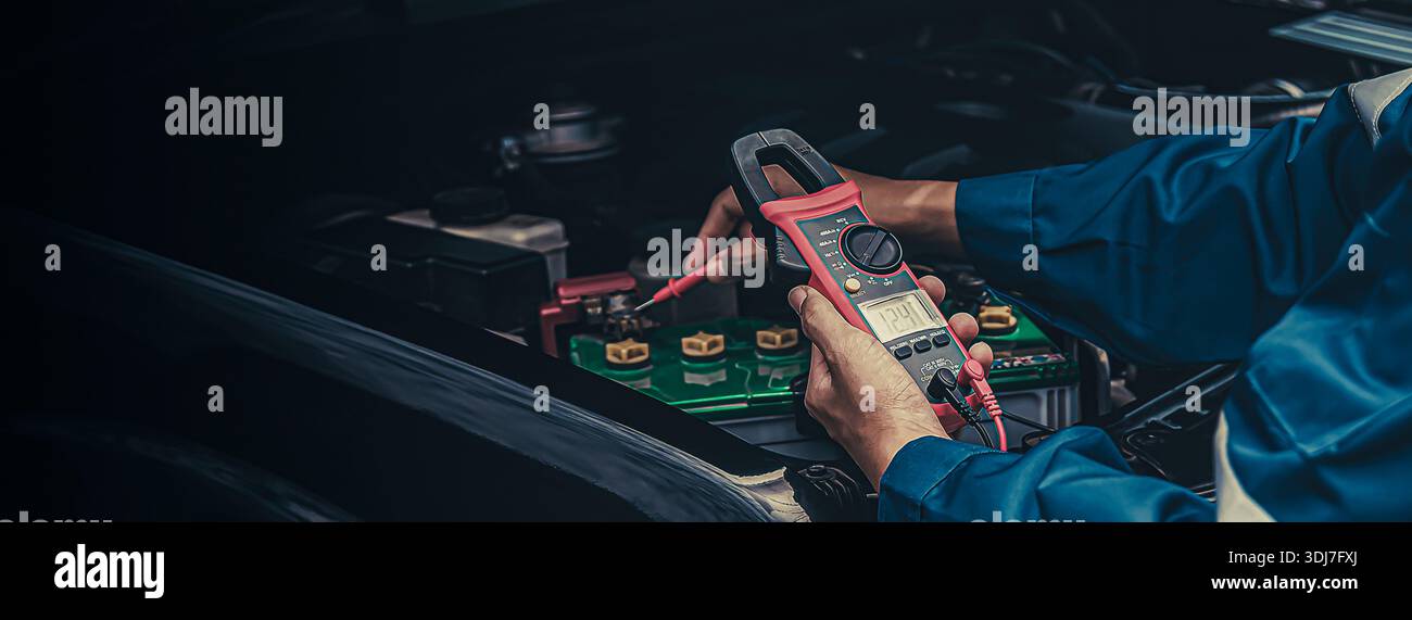 Automatische Mechaniker verwenden Voltmeter, um die Batteriespannung zu prüfen. Stockfoto