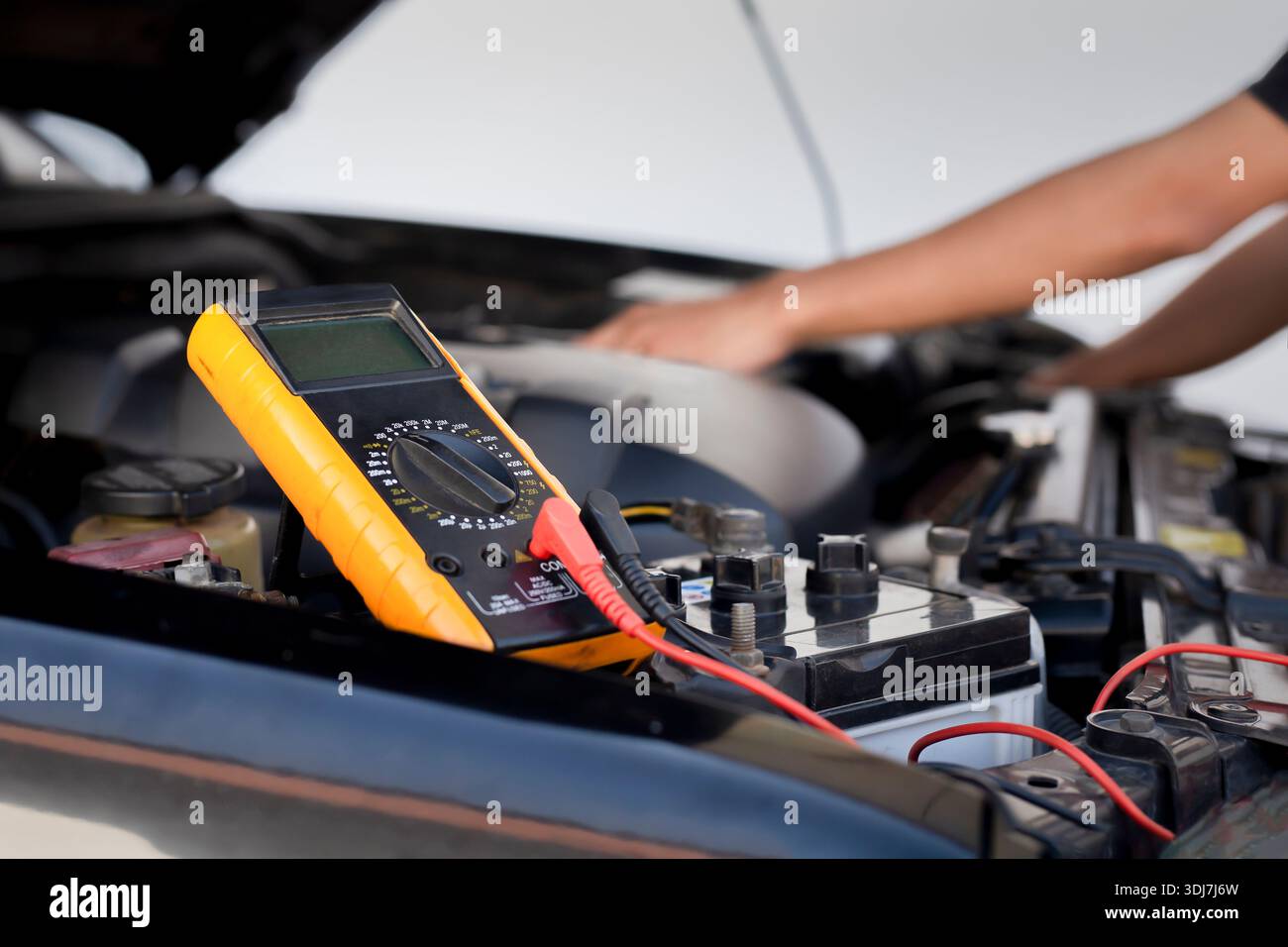 Automatische Mechaniker verwenden Voltmeter, um die Batteriespannung zu prüfen. Stockfoto