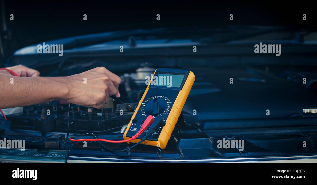 Automatische Mechaniker verwenden Voltmeter, um die Batteriespannung zu prüfen. Stockfoto