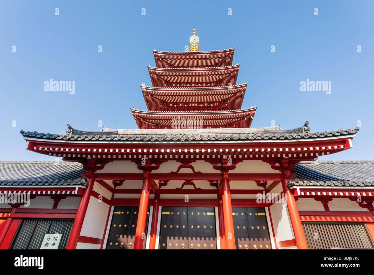 Niedriger Blick auf die fünfstöckige, kupferne Pagode am Senso-JI-Tempel, AKA Asakusa kannon Tempel, vor einem klaren blauen Himmel. Sonnenschein. Stockfoto