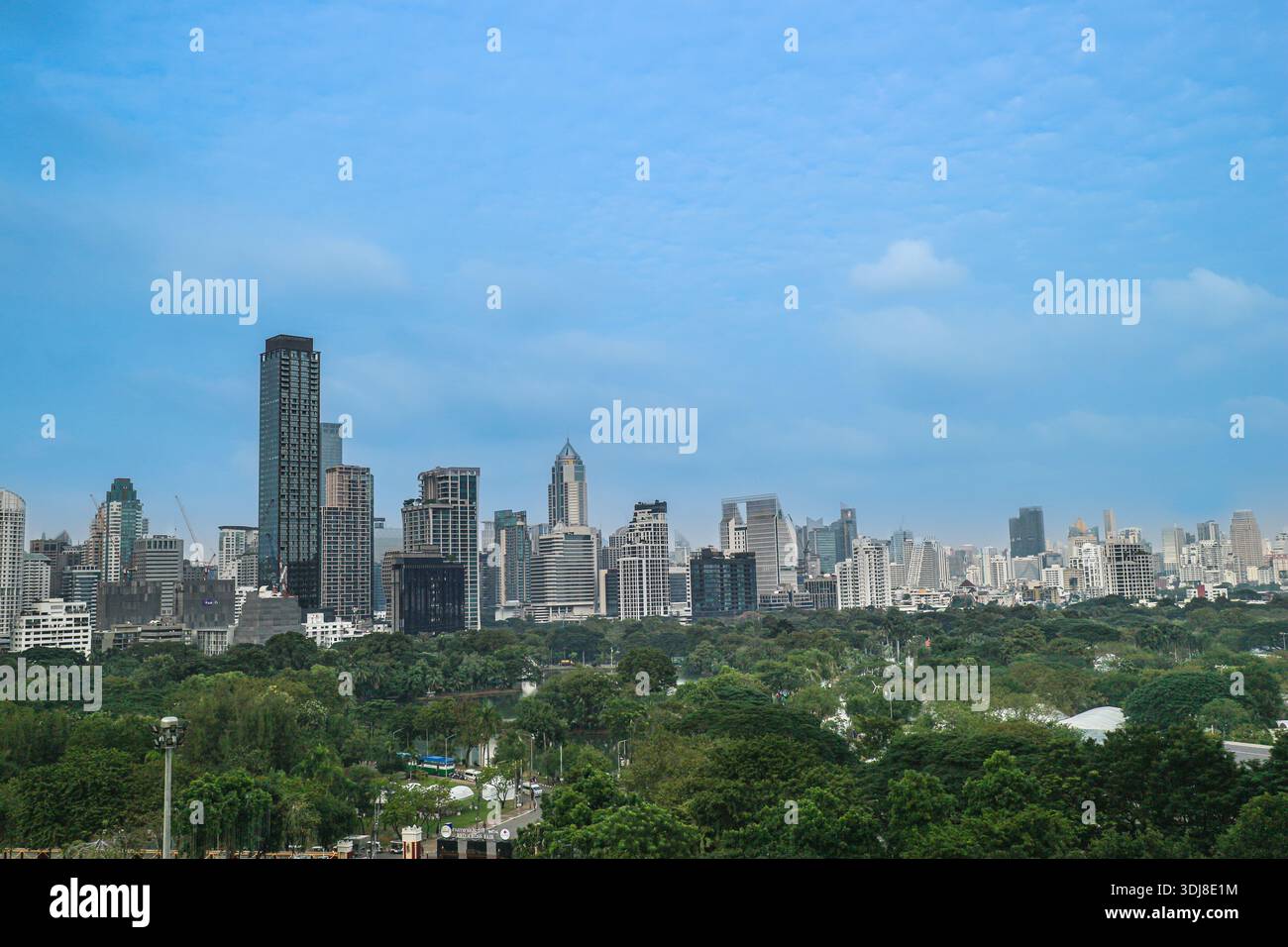 Skyline von Bangkok mit grünem Park unter dem Himmel. Gegenüberstellung von modernen Wolkenkratzern und üppiger urbaner Natur in Thailand. Stockfoto