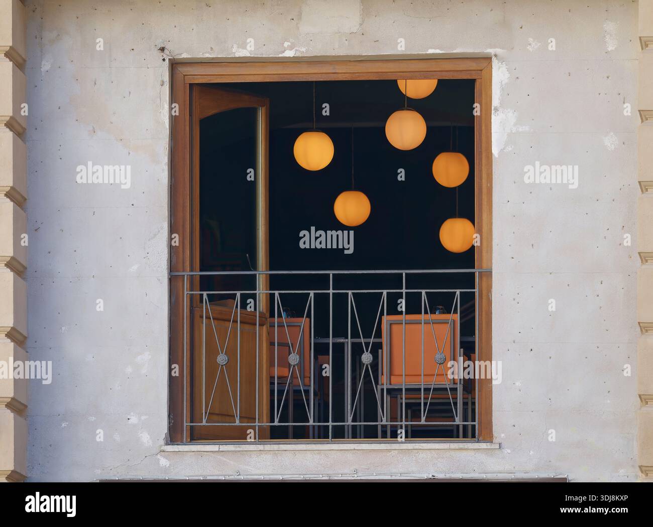 Fenster mit Blick auf das gemütliche Café-Interieur mit warmen Hängeleuchten Stockfoto