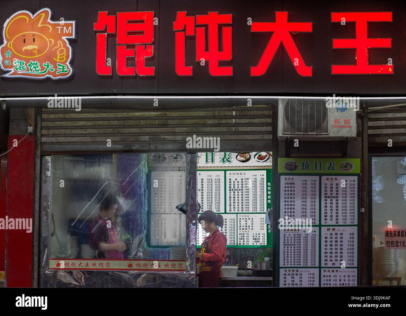 Blick von der Straße auf eine Kellnerin, die eine Bestellung in einem Restaurant entgegennimmt. Chongqing. China Stockfoto