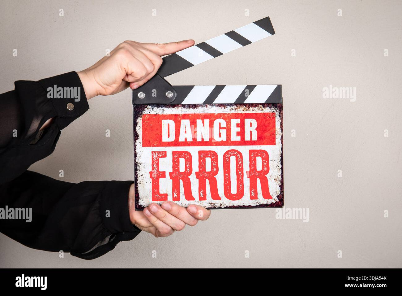GEFAHRENFEHLER in der Clapperboard-Nachricht, die von Hand gehalten wird und das Ausfallrisiko und den kritischen Fehler symbolisiert Stockfoto