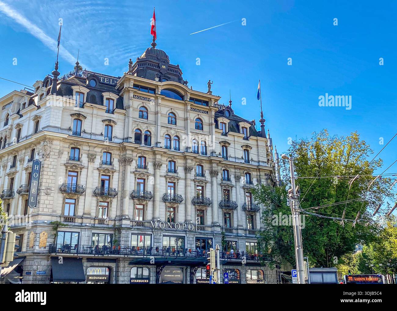 LUZERN, SCHWEIZ - 1. OKTOBER 2021: Sonniger Blick auf die Fassade des historischen Hotels Monopol. Das Bild zeigt die prunkvolle barocke Architektur, - Smartphone-aufgenommenes Stockfoto