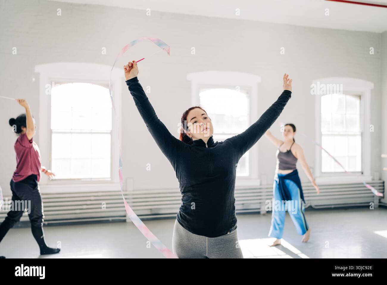 Frau hebt das Band während der Tanzübungen im Studio hoch Stockfoto
