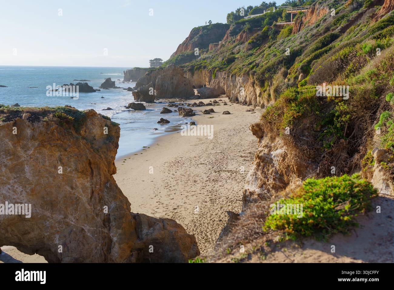Die zerklüftete Küste mit Sandsteinklippen und Meeresstapeln entlang der Sandküste des El Matador State Beach, die von natürlichem Licht beleuchtet wird. Stockfoto