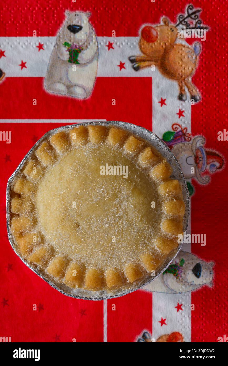 Tiptree Patisserie weihnachtlicher Hackkuchen, tief gefüllt auf festlicher Serviettenserviette - Nahaufnahme mit Blick von oben nach unten Stockfoto
