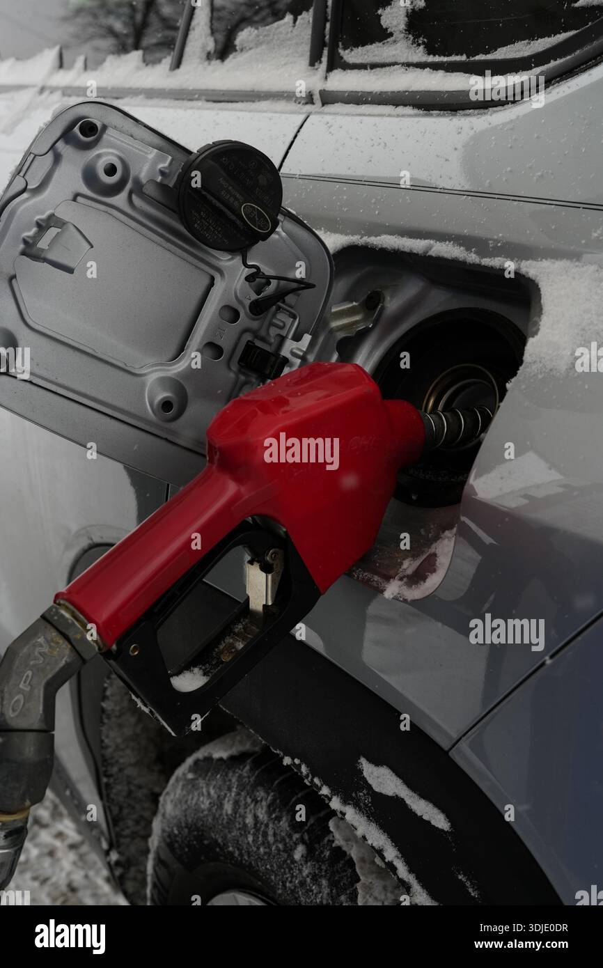 Nahaufnahme einer Kraftstoffdüse, die an einer Tankstelle in einen Autogastank eingeführt wurde. Tankstelle, Kraftstoffpumpendüse im Tank Stockfoto