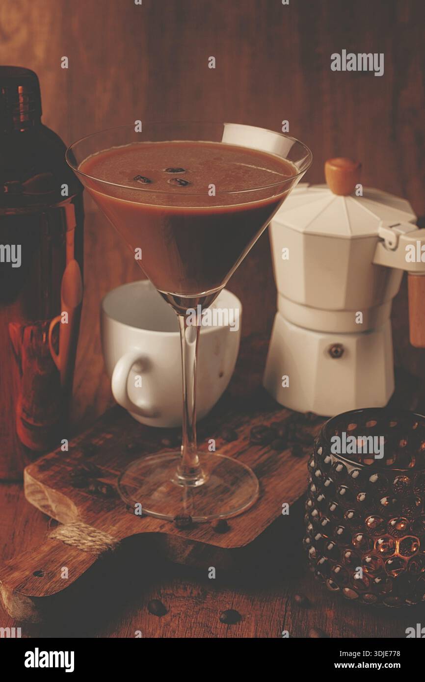 Espresso-Martini-Cocktail, alkoholisches Getränk, Shaker und Geysir-Kaffeemaschine, auf hölzernem Hintergrund Stockfoto