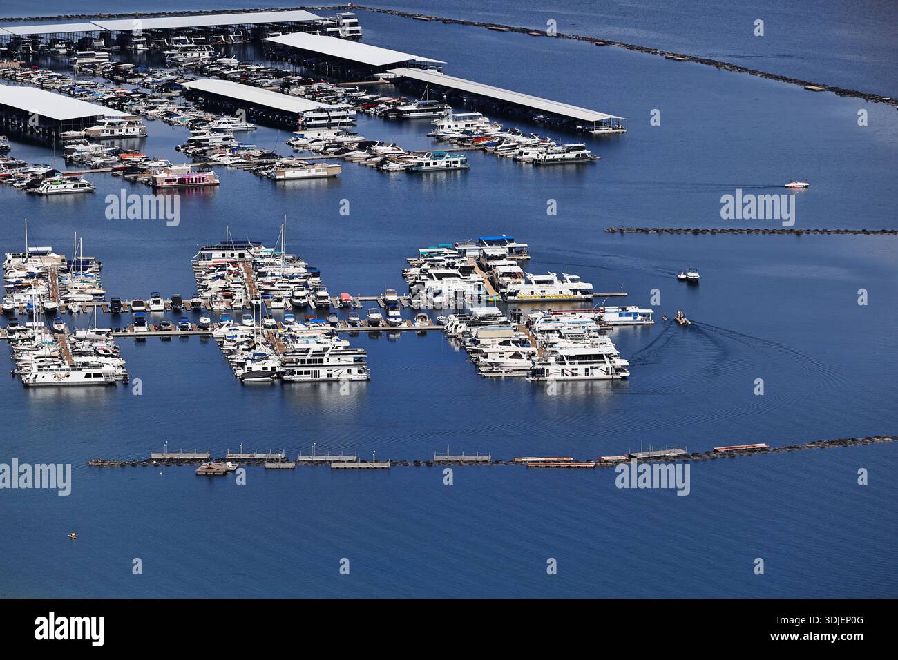 Überdachte Docks und Bootsreihen füllen einen geschäftigen Yachthafen am Lake Mead in der Lake Mead National Recreation Area, USA, mit Wellenbrechern und Wachen im Wasser. Stockfoto