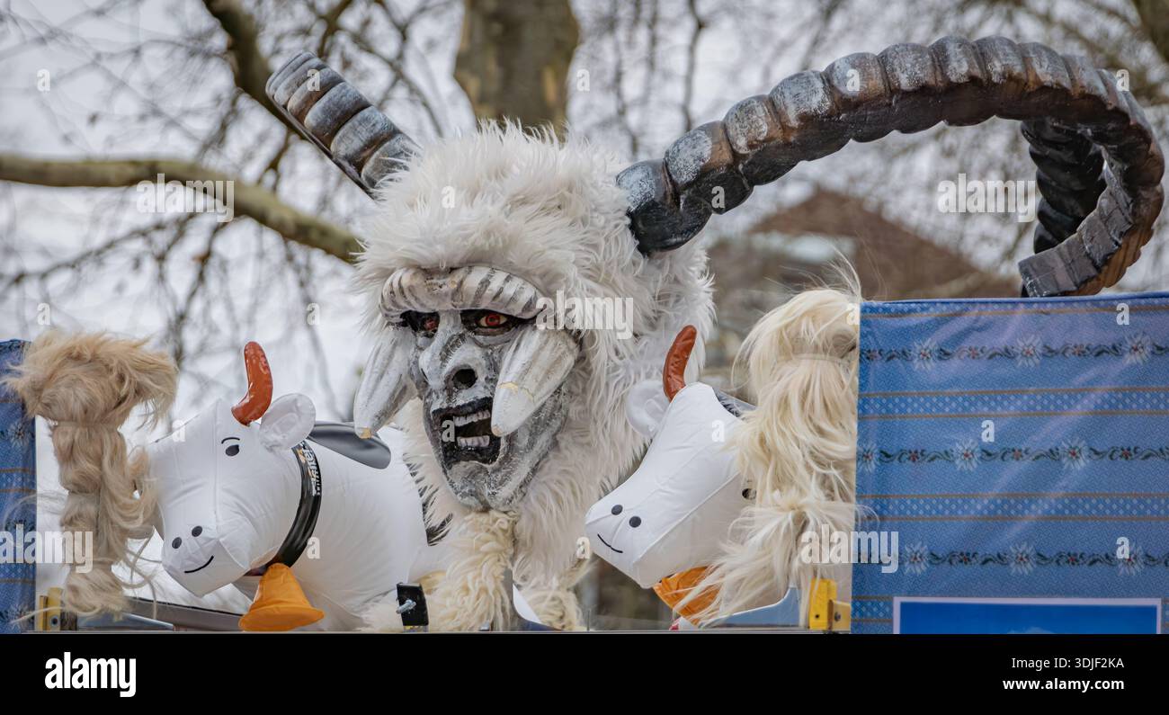 Zug, Schweiz - 1. März 2025: Eine Person in einem Tschaggatta, pelzigen Tierkostüm mit gehörnter Holzmaske bei einer Schweizer Winterkarnevalsparade Stockfoto