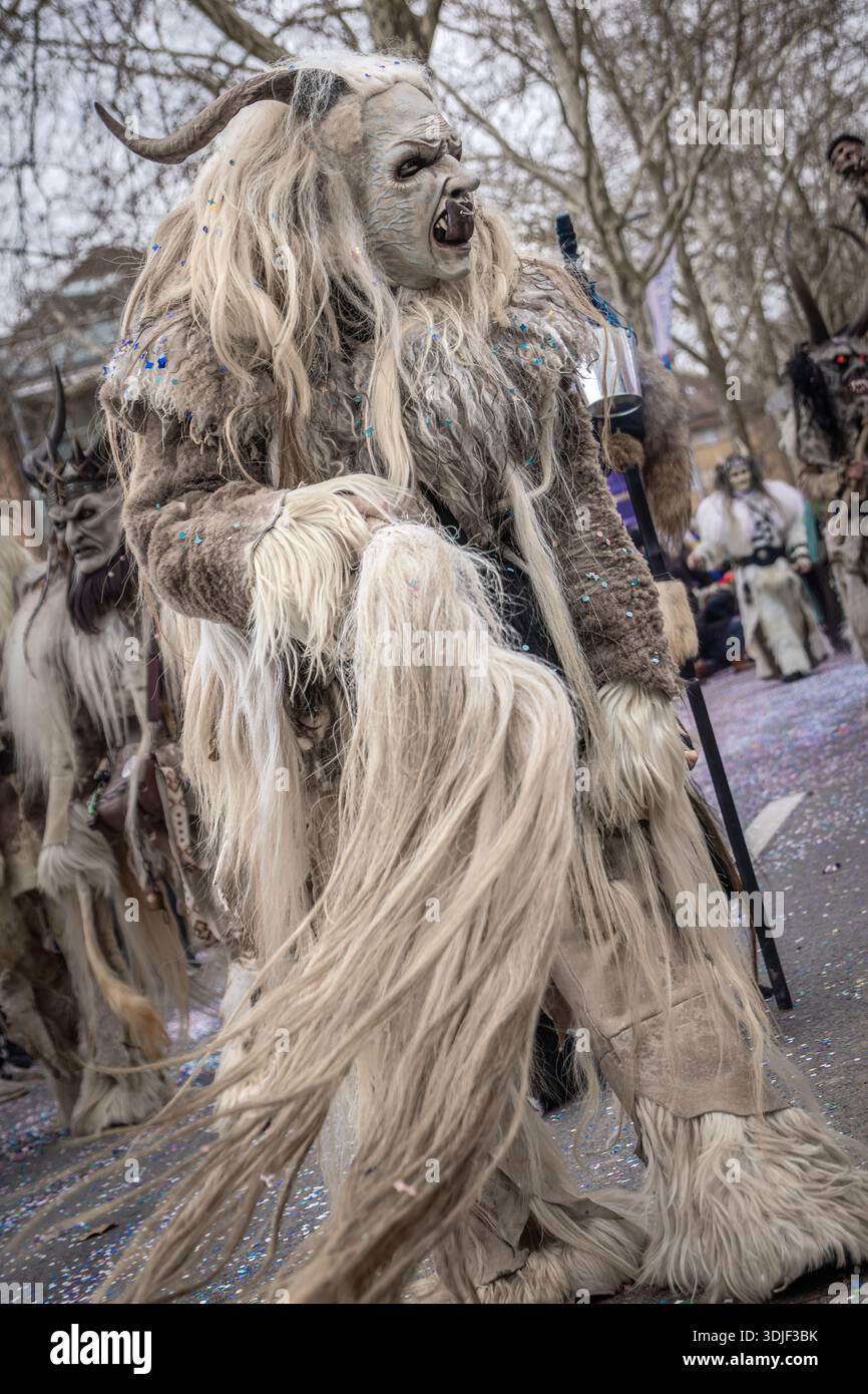 Zug, Schweiz - 1. März 2025: Eine Person in einem Tschaggatta, pelzigen Tierkostüm mit gehörnter Holzmaske bei einer Schweizer Winterkarnevalsparade Stockfoto