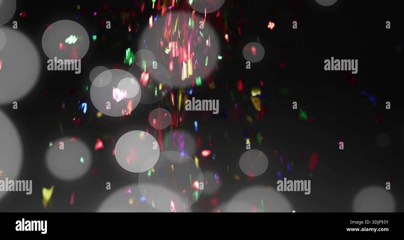 Buntes Konfetti und durchscheinendes Bokeh, das durch die dunkle Kulisse mit Glitzer gleitet Stockfoto