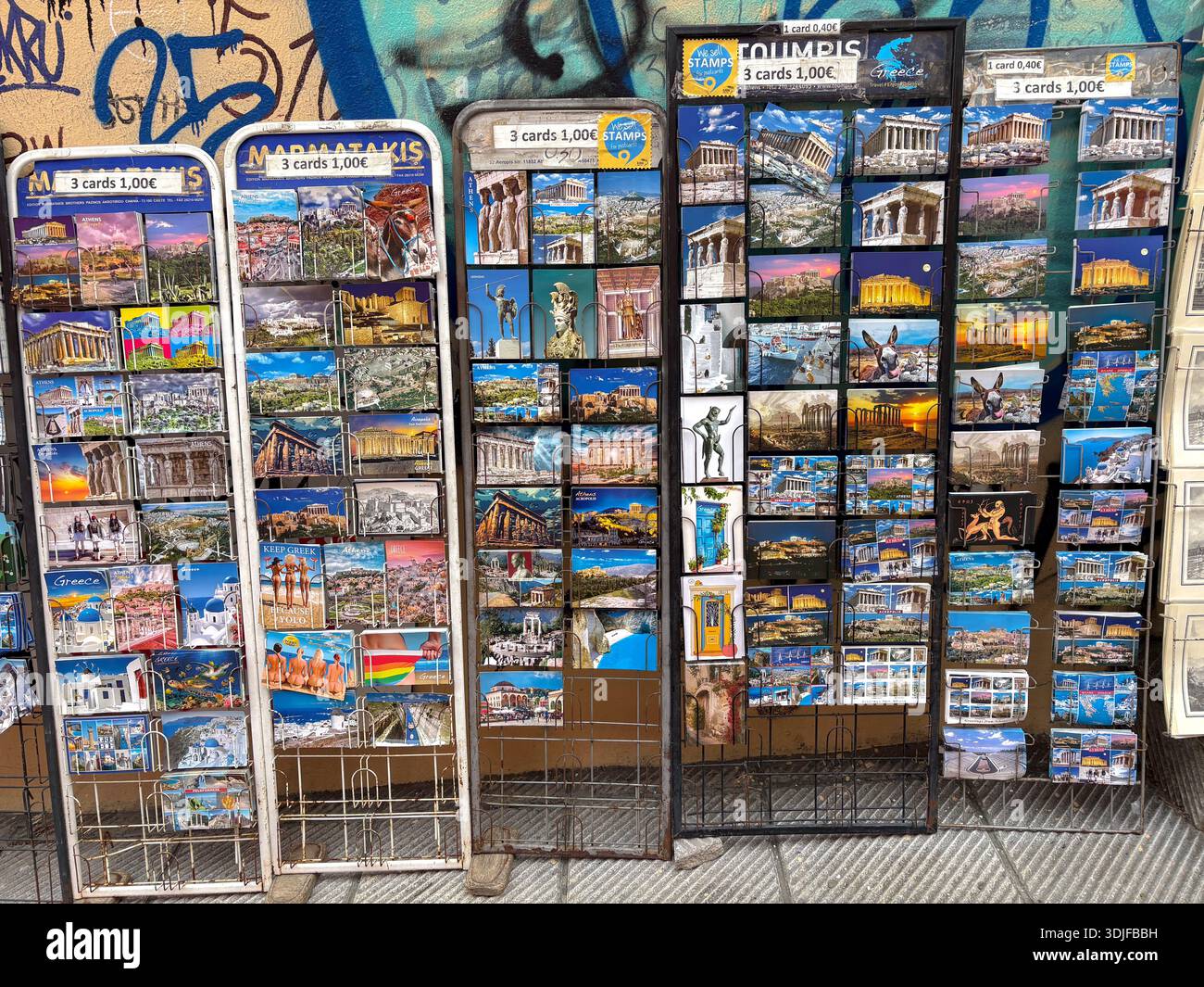 Souvenir-Postkarten Ausstellungsständer in Athen, Griechenland. Mit Blick auf Parthenon, Akropolis und griechische Szenen. Preisschilder weisen auf 3 Karten für 1,0 hin Stockfoto