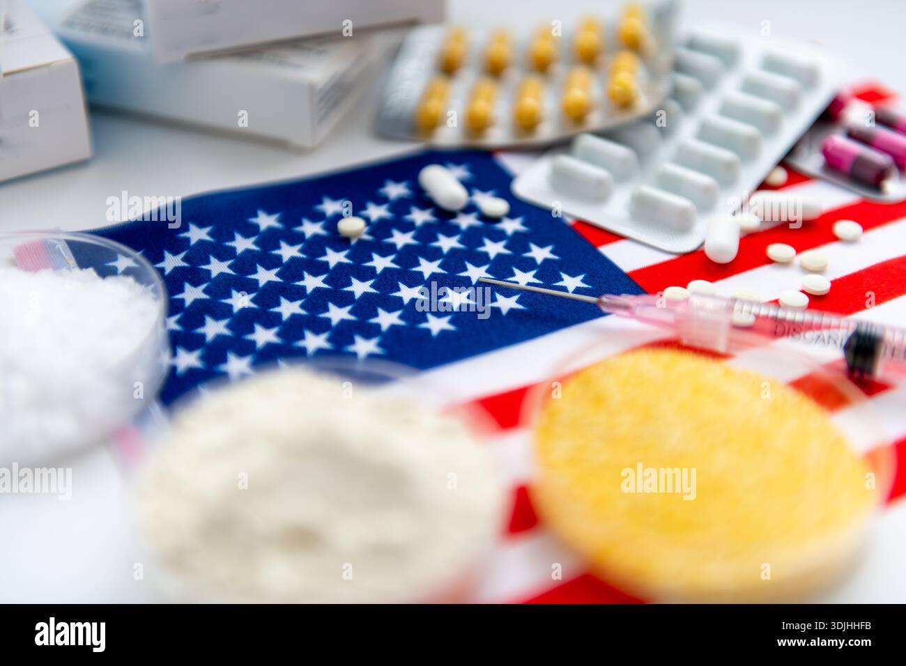 Ein amerikanisches Arzneimittelkonzept mit einer Nahaufnahme von Arzneimittelgrundstoffen in Glasschalen, verschiedenen losen Arzneimitteltabletten und Verpackungen auf dem fla Stockfoto