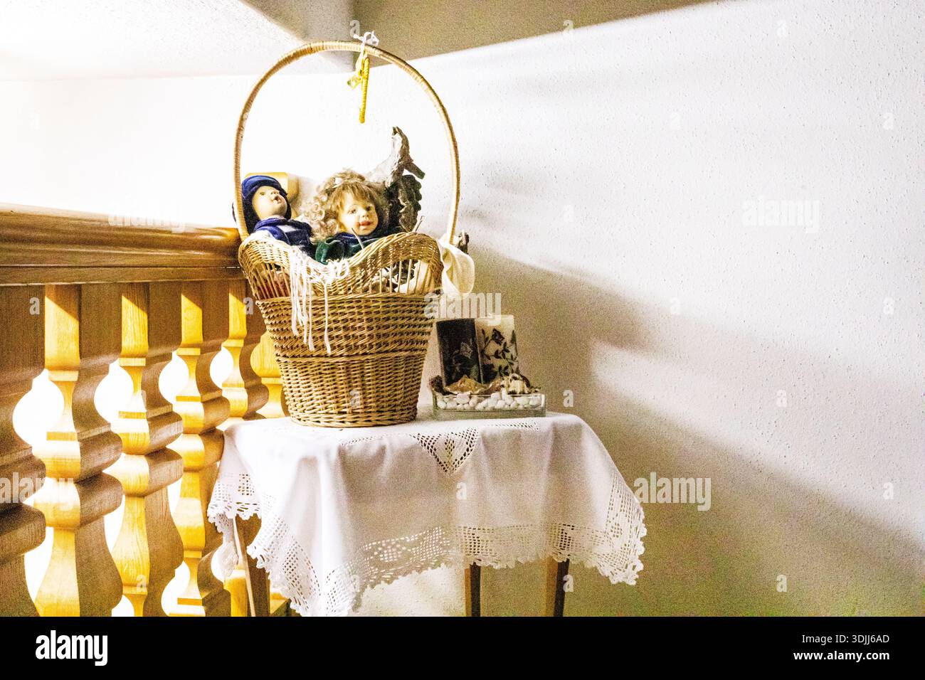 Niedliche Porzellanpuppen in einem Korb neben der Tür im Flur. Retro-STYLE. Stockfoto