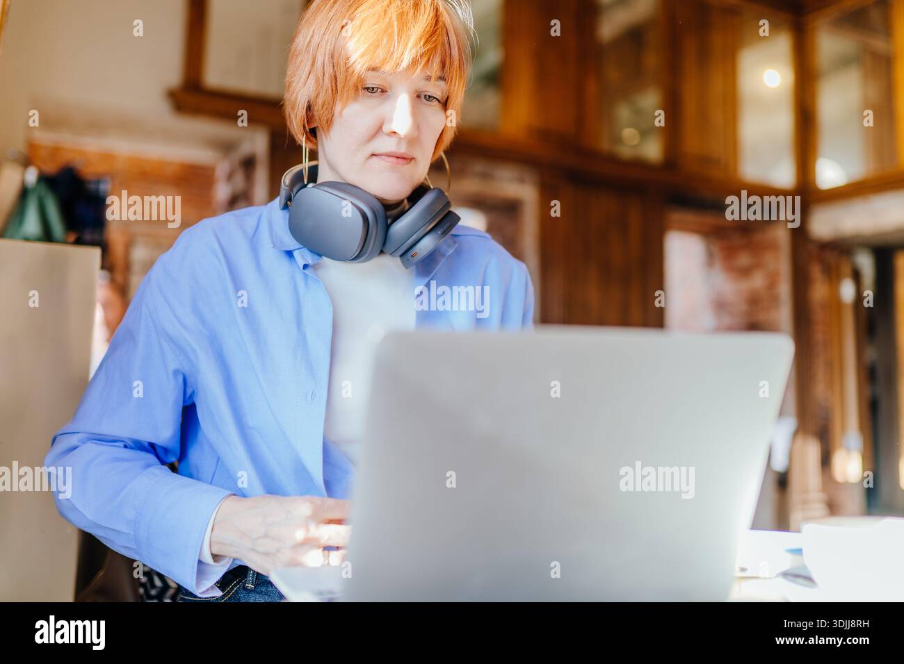 Fokussierte professionelle Frau analysiert Daten auf Laptop im Café Stockfoto