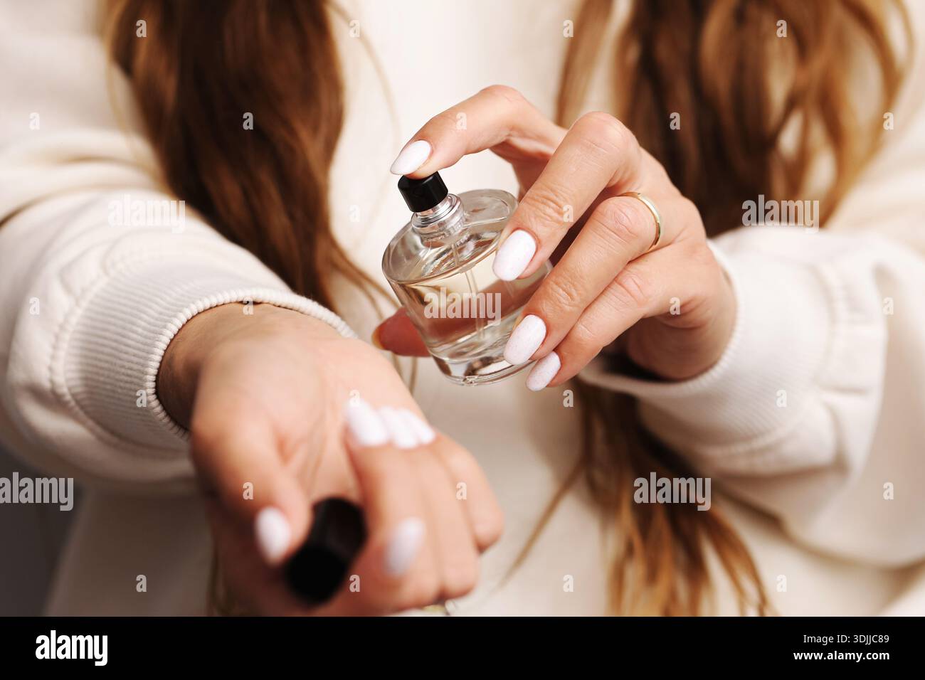Parfüm auf Handgelenknaht auftragen. Weiblicher Handduft. Tägliche Schönheits- und Selbstpflegeroutine. Elegantes Lifestyle-Detail. Stockfoto